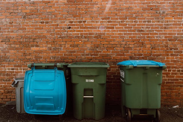 a bunch of garbage cans lined up outside a building