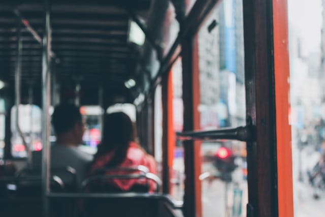 interior of a city bus with two passengers sitting next to each other